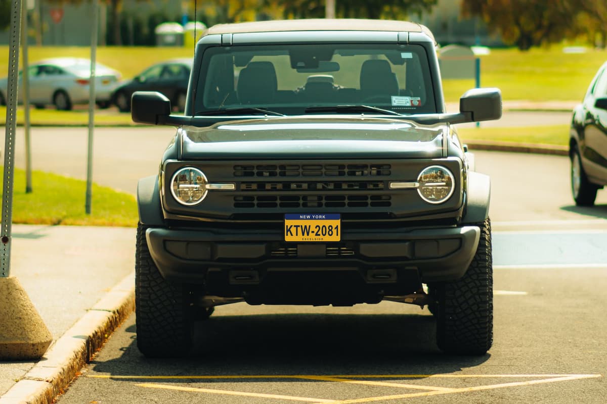 A gray 2022 Ford Bronco pulling up to the gate. Its plate, KTW2081, is invented.